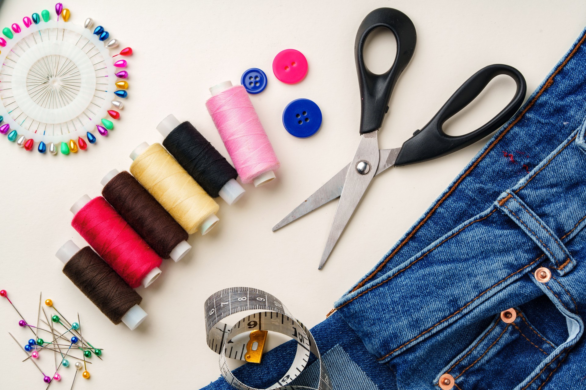 Sewing supplies and denim fabric arranged on a workspace